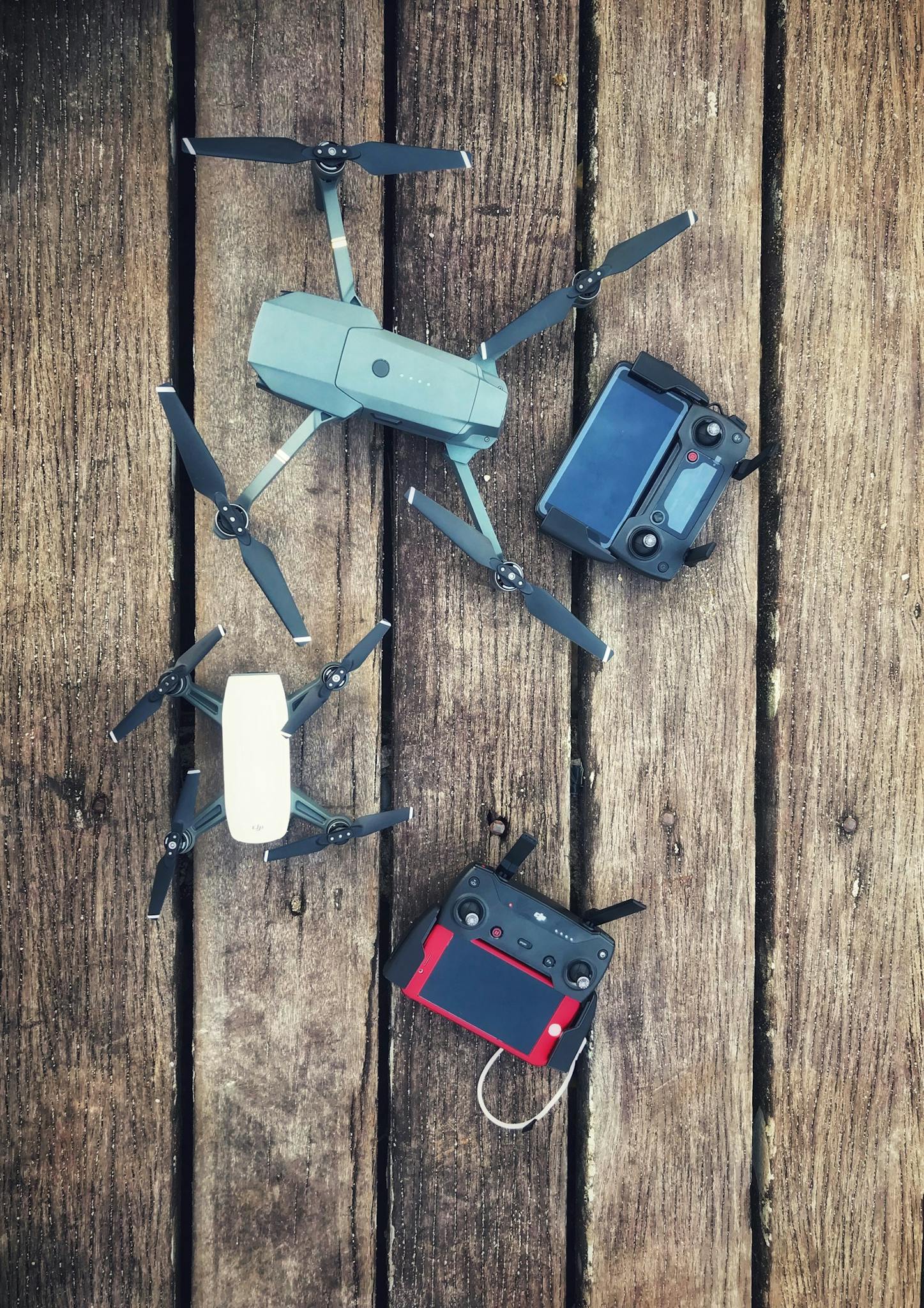 Aerial equipment and controllers displayed on a wooden backdrop, showcasing modern drone technology.